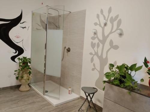 a bathroom with a shower with a painting of a woman at FalcoBianco GuestHouse in Montefalco