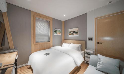 a bedroom with two beds and a window at Pohang Villa Dahlia in Pohang