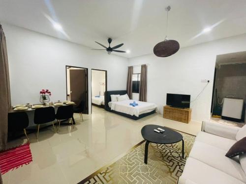 a living room with a couch and a bed and a table at Ferringhi Beach Guesthouse-3bed in Batu Ferringhi