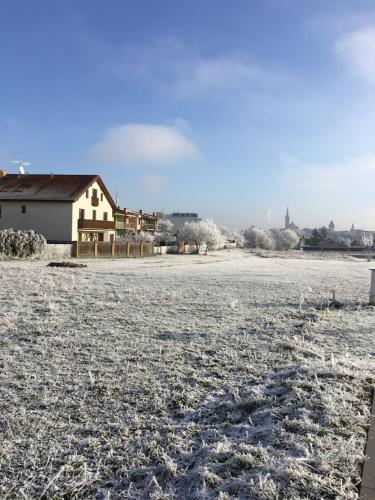 a field covered in snow with a house in the background at Pension 325 in Tábor