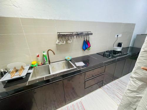 a kitchen with a sink and a counter top at Ferringhi Beach Guesthouse-3bed in Batu Ferringhi