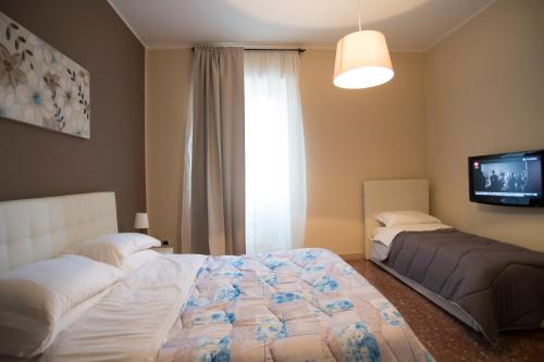 a bedroom with two beds and a tv and a window at Capital flat 9-A in Rome