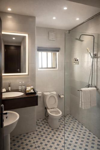 a bathroom with a toilet and a sink and a shower at Lake Court Residence in Abuja