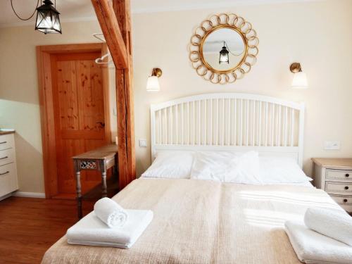 a bedroom with a large white bed with towels on it at Penzion V peřině in Trojanovice