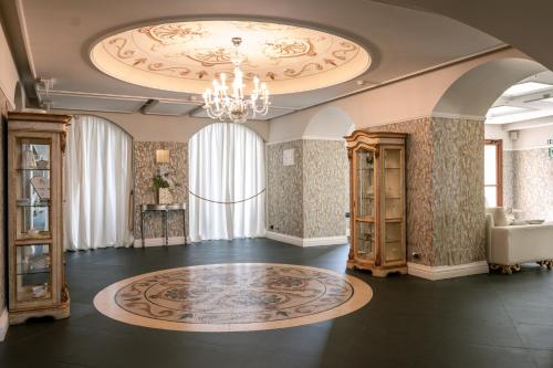 a large room with a chandelier and a rug at Essence Sicily - Marina Holiday Hotel & Spa in Balestrate