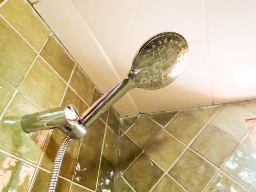 a shower with a shower head in a bathroom at Sunset Surfhouse Morocco in Tamraght Ouzdar