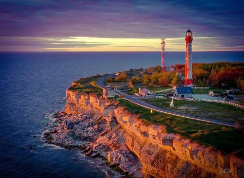 a lighthouse on a cliff next to the ocean at Pakri lighthouse camping in Paldiski