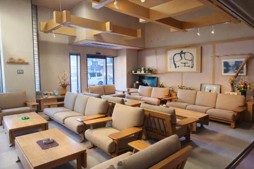 a waiting room with couches and tables at ホテル秘境の湯 in Miyoshi