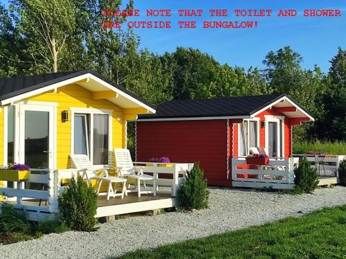 a small yellow and red shed with a patio at Pakri lighthouse camping in Paldiski