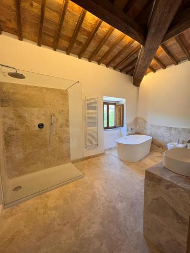 a bathroom with two sinks and a tub and a shower at Agriturismo il Canneto in Casole dʼElsa