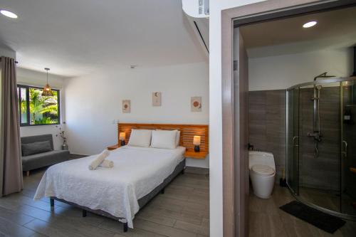 a bedroom with a bed and a bathroom with a shower at Yuli Hotel in Uvita