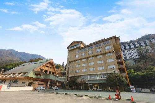 a large building next to a parking lot at ホテル秘境の湯 in Miyoshi