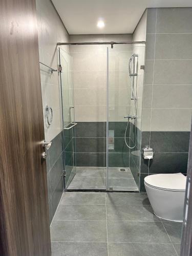a bathroom with a glass shower with a toilet at 1BR Olive & Rouge House in Long Bình