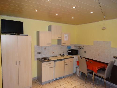 cocina con mesa y cocina pequeña con mesa y sillas en Pension Wolkenstein, en Langenbruck