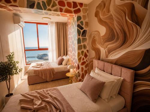 a bedroom with two beds and a window with the ocean at Beachfront Central Boutique Apartments in Durrës
