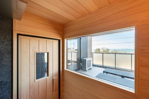a room with a door and a large window at YUTORELA 富津 with SAUNA プライベートサウナ完備 in Futtsu