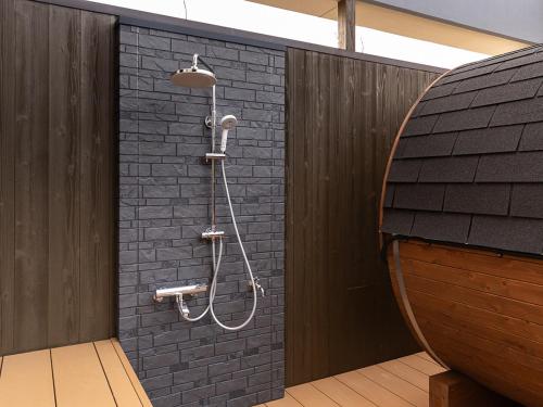 a bathroom with a shower in a brick wall at 汐の丸 in Imabari