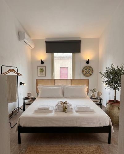 a bedroom with a large white bed with two towels on it at Be Local-Avola stay in Avola