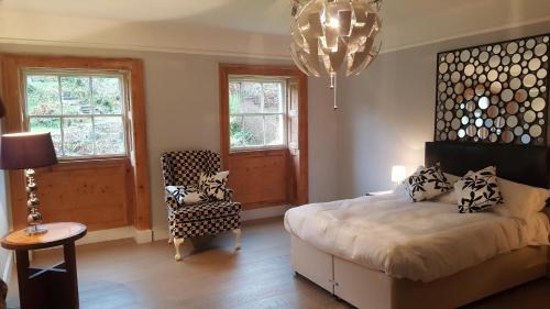 - une chambre avec un lit, une chaise et un lustre dans l'établissement Grigshot Apartment, à Stroud