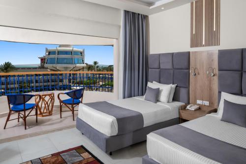 a hotel room with two beds and a balcony at Seagull Beach Resort - Families and Couples Only in Hurghada