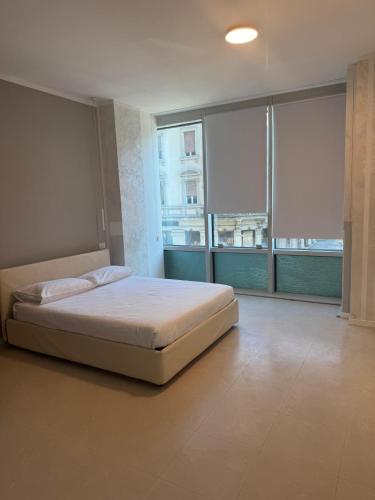 a large bedroom with a bed and large windows at Duca d Aosta apartment 2 in Monfalcone