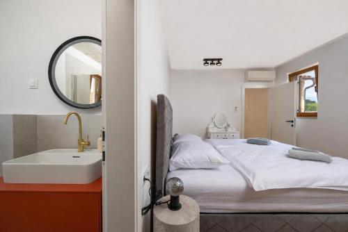 a bedroom with a bed and a sink and a mirror at Villa Sofija in Vodnjan