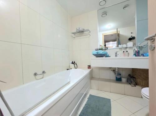 a white bathroom with a tub and a sink at Vozinha Residence in Prainha