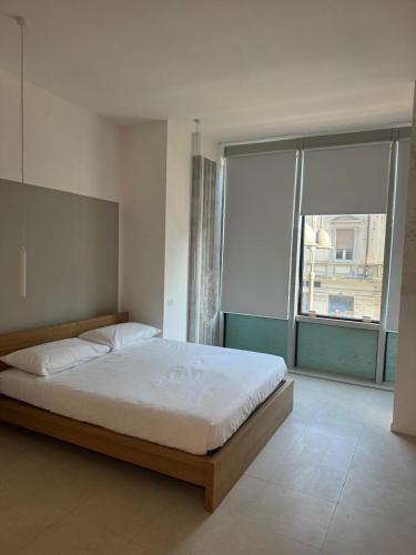 a bedroom with a large bed and a large window at Duca d Aosta apartment 4 in Monfalcone