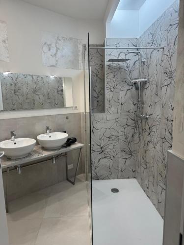 a bathroom with two sinks and a shower at Duca d Aosta apartment 4 in Monfalcone
