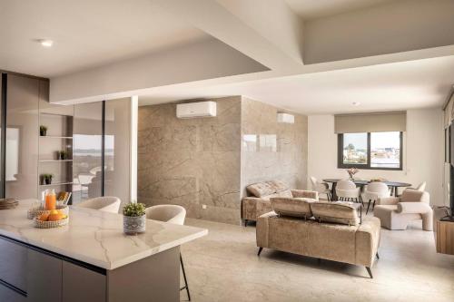 a kitchen and living room with a couch and a table at Lake View Suites in Paralimni