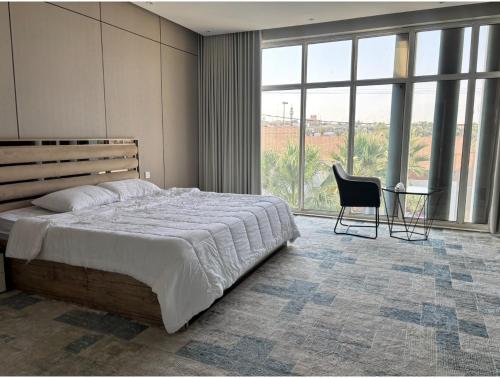 a bedroom with a bed and a table and a chair at شاليه بالم ون و فيلورا الفندقي in Buraydah
