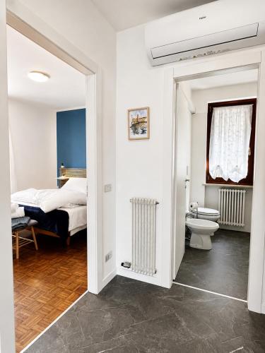 a bedroom with a bed and a bathroom with a toilet at Azzurra Beths House in Brenzone sul Garda