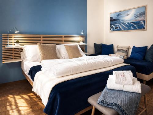 two beds in a room with a blue wall at Azzurra Beths House in Brenzone sul Garda