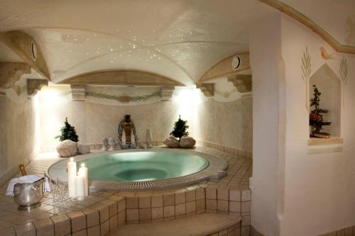 un bagno con vasca idromassaggio con alberi di Natale di Hotel Al Sonnenhof a San Vigilio Di Marebbe