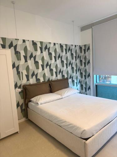 a bedroom with a bed with a headboard and a wall at Duca d Aosta apartment 3 in Monfalcone