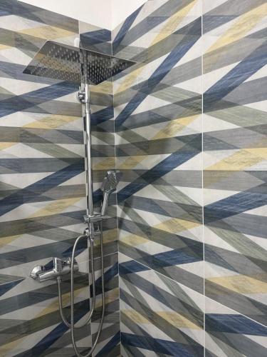 a bathroom with a shower with a checkered wall at Duca d Aosta apartment 3 in Monfalcone