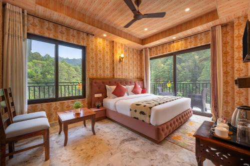 a bedroom with a bed and a large window at A Mountains Suffer Hotel Kasauli Near Kasauli Hills Resort by Splendid Retreat Hotels - Family Groups - Balcony - Parking - Mountain View - River View - Forest Treks - Vacation - Memories in Kasauli