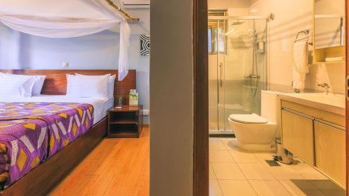 a bedroom with a bed and a shower and a toilet at Heaven Boutique Hotel in Kigali