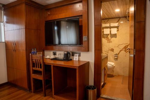 a bathroom with a desk with a television and a toilet at Hotel Kailash Kutee in Kathmandu