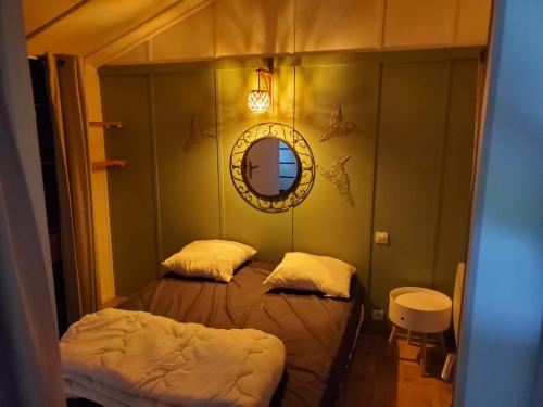 a small bedroom with two beds and a mirror at Les chalets du Causse Confort Climatisé in Gelle
