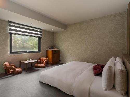 a bedroom with a large white bed and a window at The Zen in Jiufen