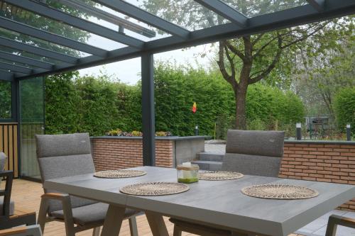 a patio with a table and chairs under a pergola at Eifeltraum Marianus in Nieder-Emmels