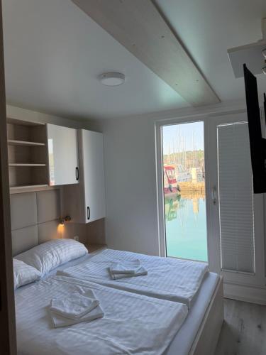 a bedroom with a bed and a large window at JungleHouse - Floating House in Portorož