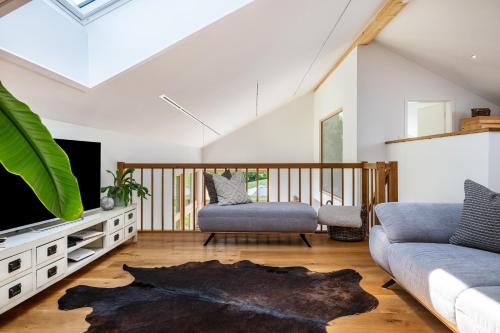 a living room with a couch and a tv at Chalet Bergblick in Rimsting