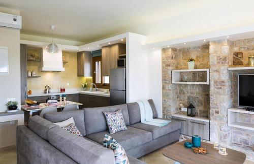 a living room with a couch and a kitchen at Muses Beach Villas - Urania in Sitia