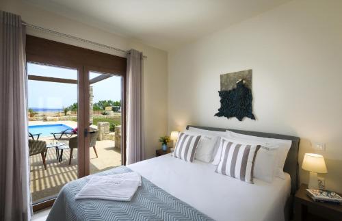 a bedroom with a bed and a view of a patio at Muses Beach Villas - Urania in Sitia