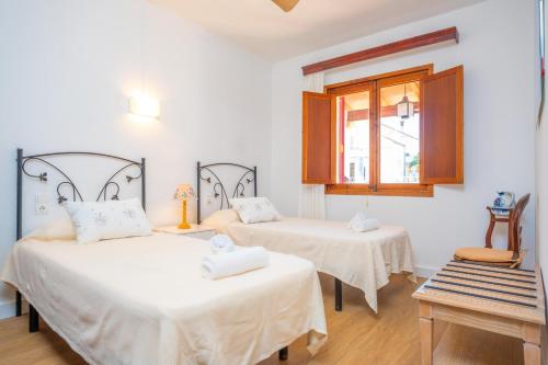 a room with two beds and a window at Can Pons in Can Picafort