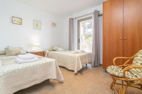 a bedroom with two beds and a window at Can Vesses in Alcudia