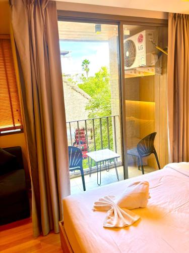 a bedroom with a bed and a view of a balcony at Adventure Studio Aonang in Ao Nang Beach