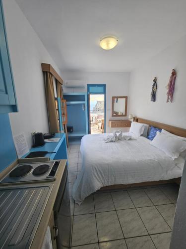 a bedroom with a bed and a kitchen with a stove at St Paul's Studios Chrysanthi in Lindos